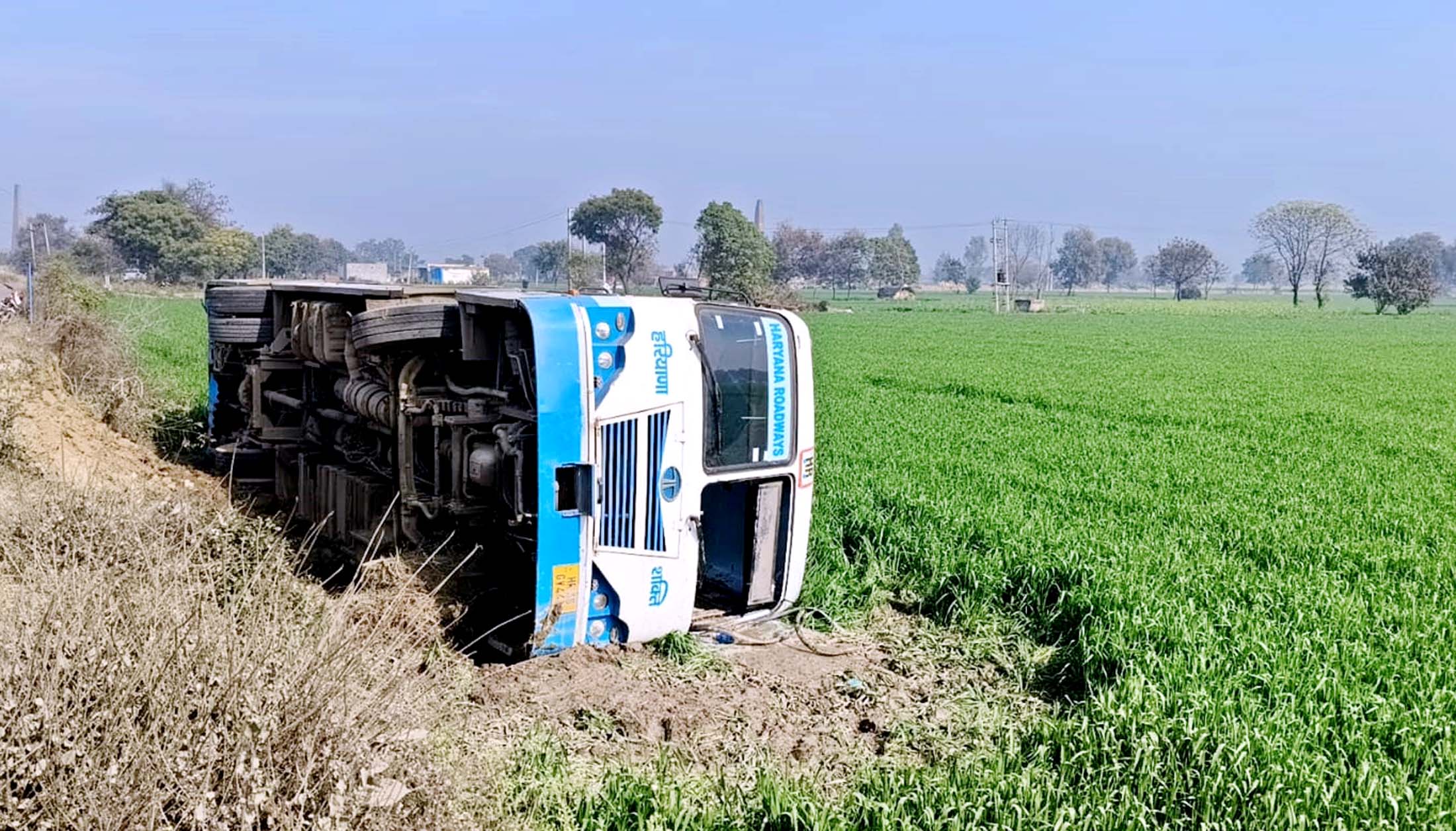 खेतों में पलटी बस।