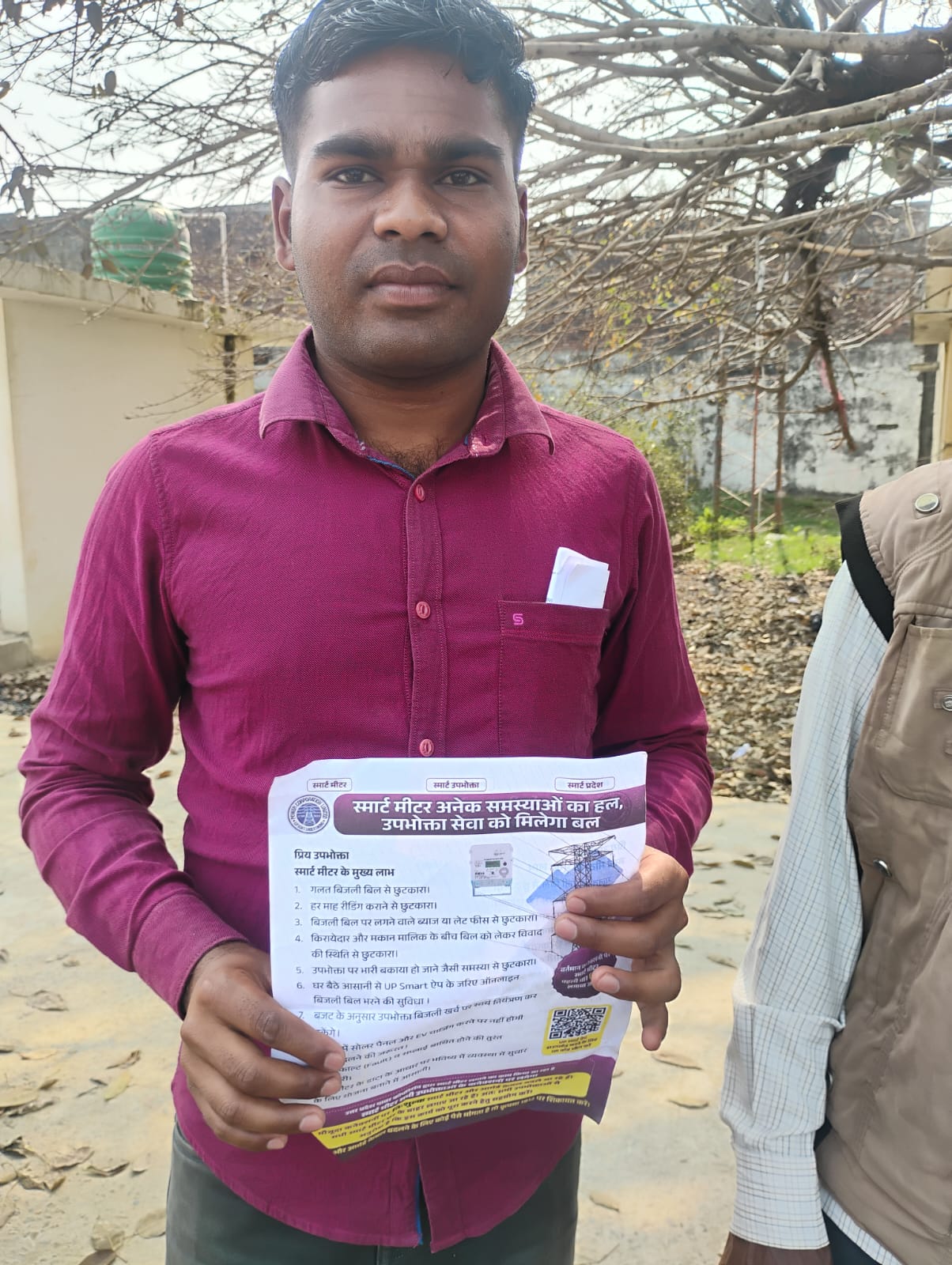 उपभोक्ता को पर्चा देकर स्मार्ट मीटर की जानकारी देते मध्यांचल विद्युत वितरण निगम के कर्मी