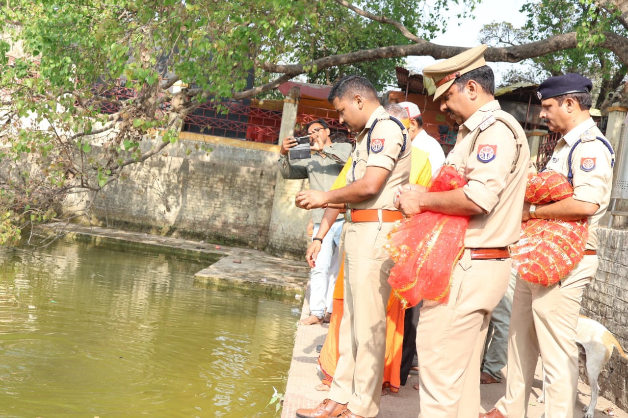 मछलियों को दाना डालते हुए पुलिस अधीक्षक