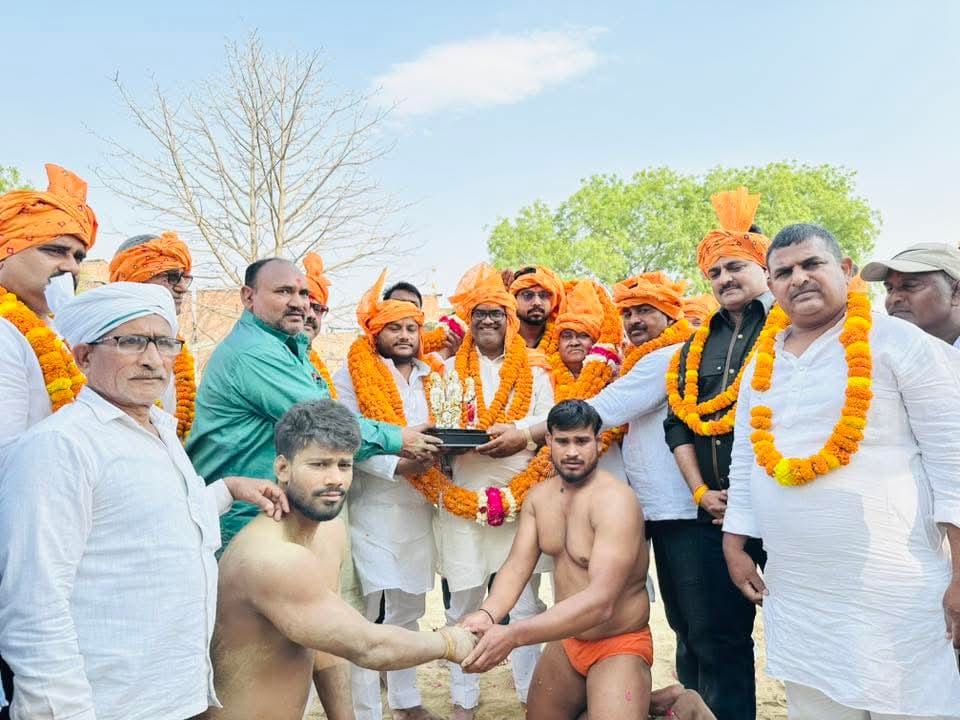 कुश्ती प्रतियोगिता में पहलवानों का हाथ मिलवाते राज्य मंत्री गिरीश चंद्र यादव