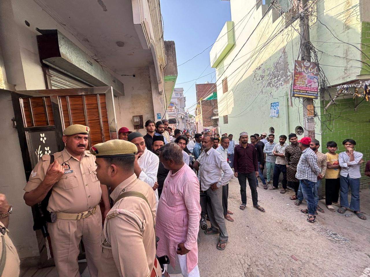 रहपुरा चौधरी गांव में दोहरे हत्याकांड के बाद मौके पर जांच करती पुलिस और जुटी ग्रामीणों की भीड़।