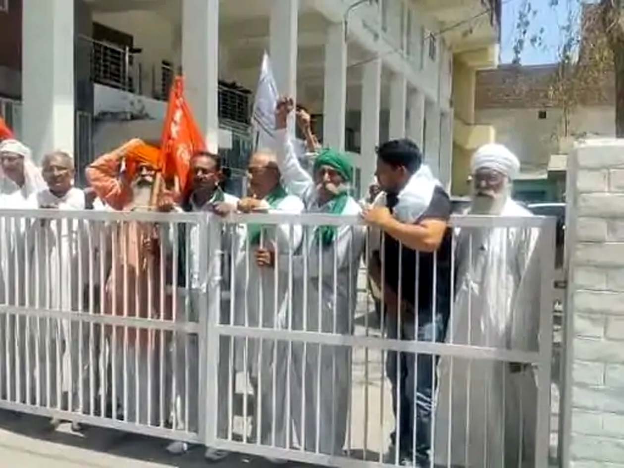 मार्केट कमेटी कार्यालय को ताला लगाते किसान।