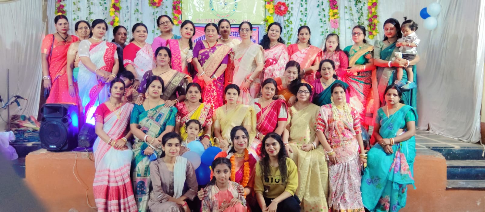 समूह में बैठी हुई महिलाएं।