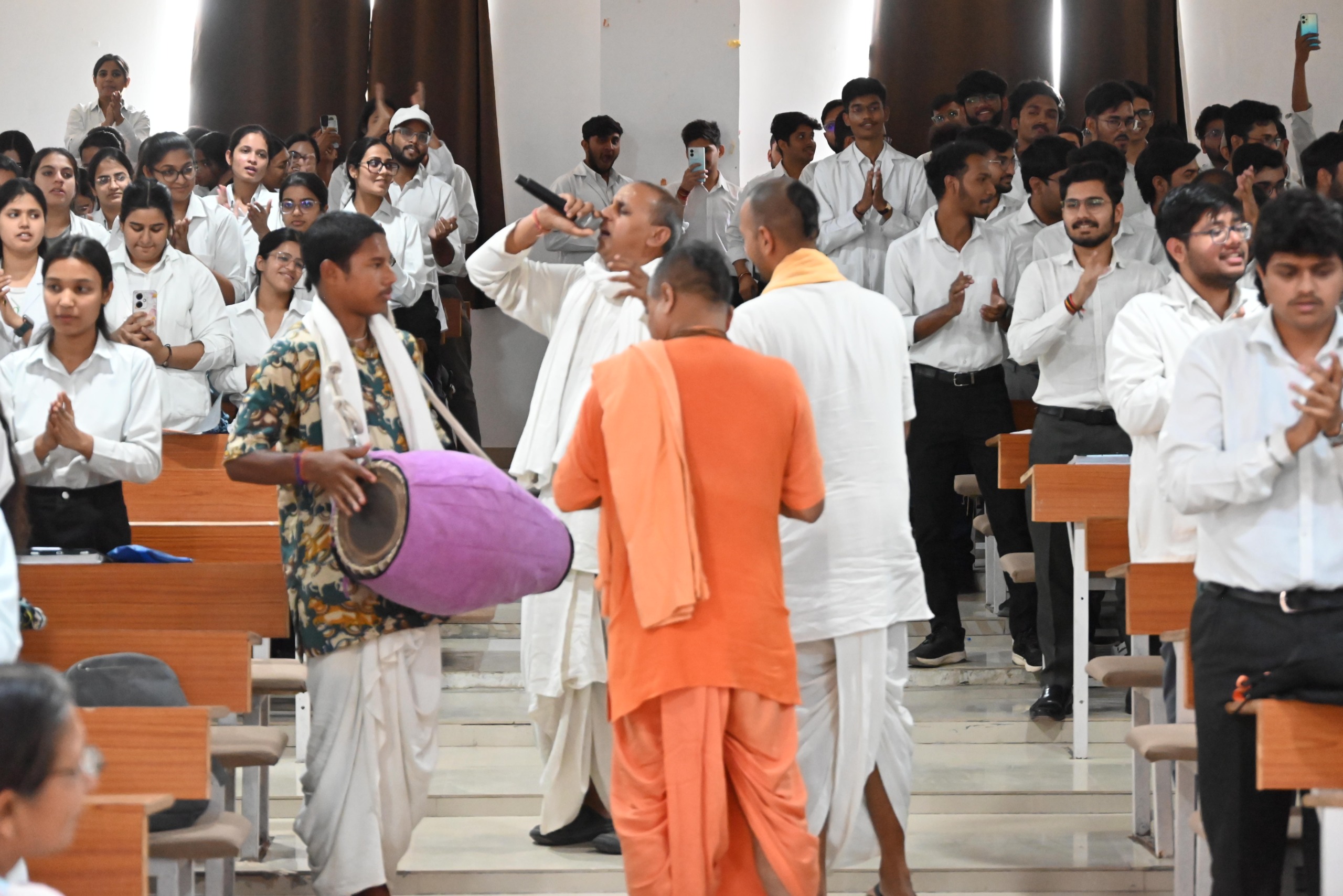 हरे कृष्ण हरे राम के महामंत्री में संकीर्तन करते हुए केएम के छात्र-छात्राएं