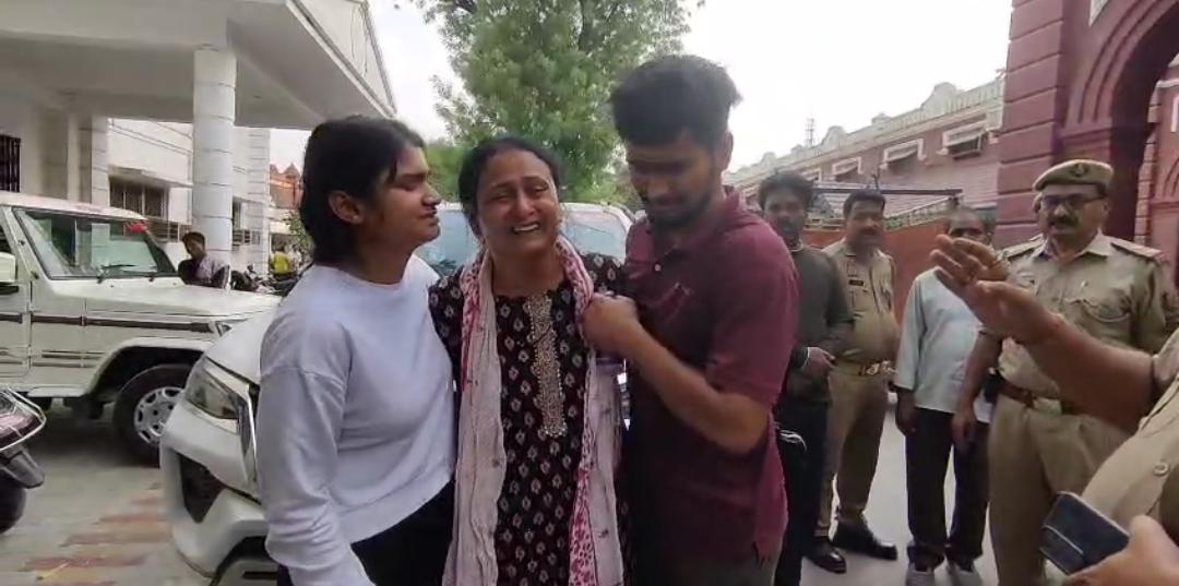 जिलाधिकारी कार्यालय के सामने अपने दोनों बच्चों के साथ रोते बिलखते हुए मृतका की पत्नी