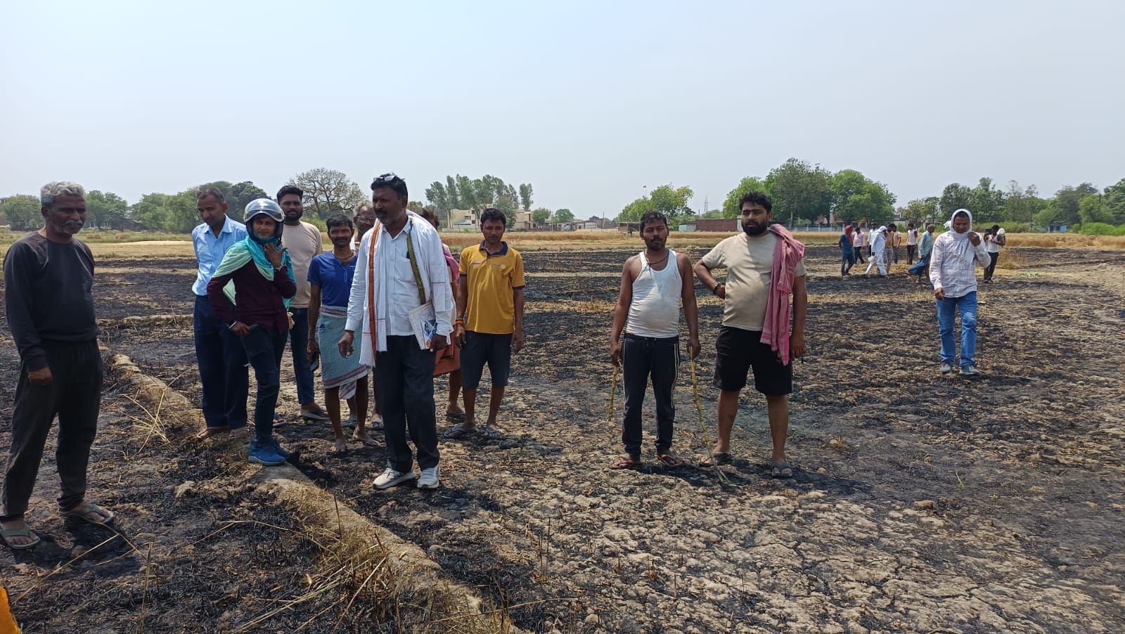 खेतों में लगी आग मौके पर पहुंचे लेखपाल नुकसना का आकलन करते हुए